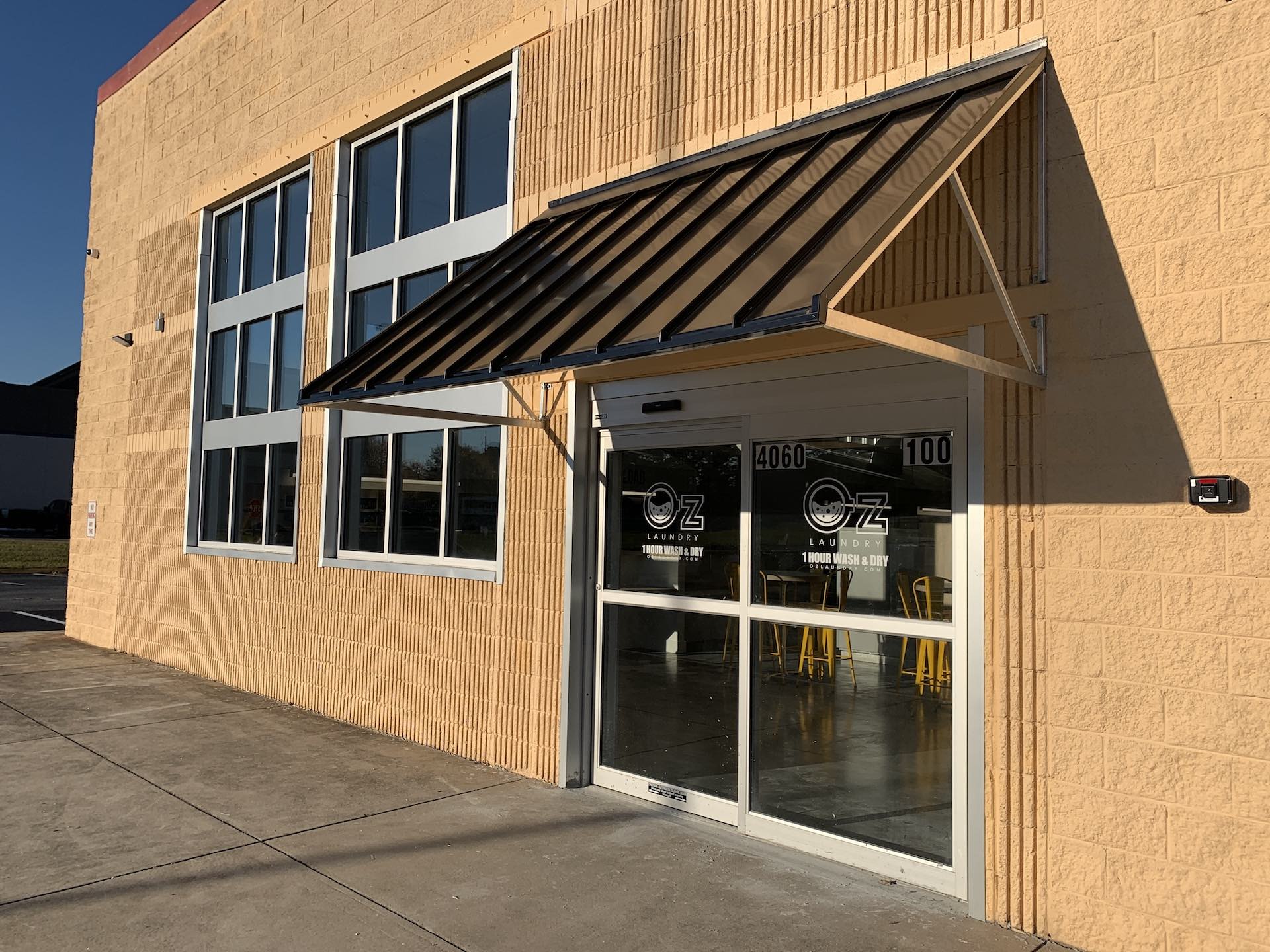 Oz Laundry storefront on Covington Highway at golden hour