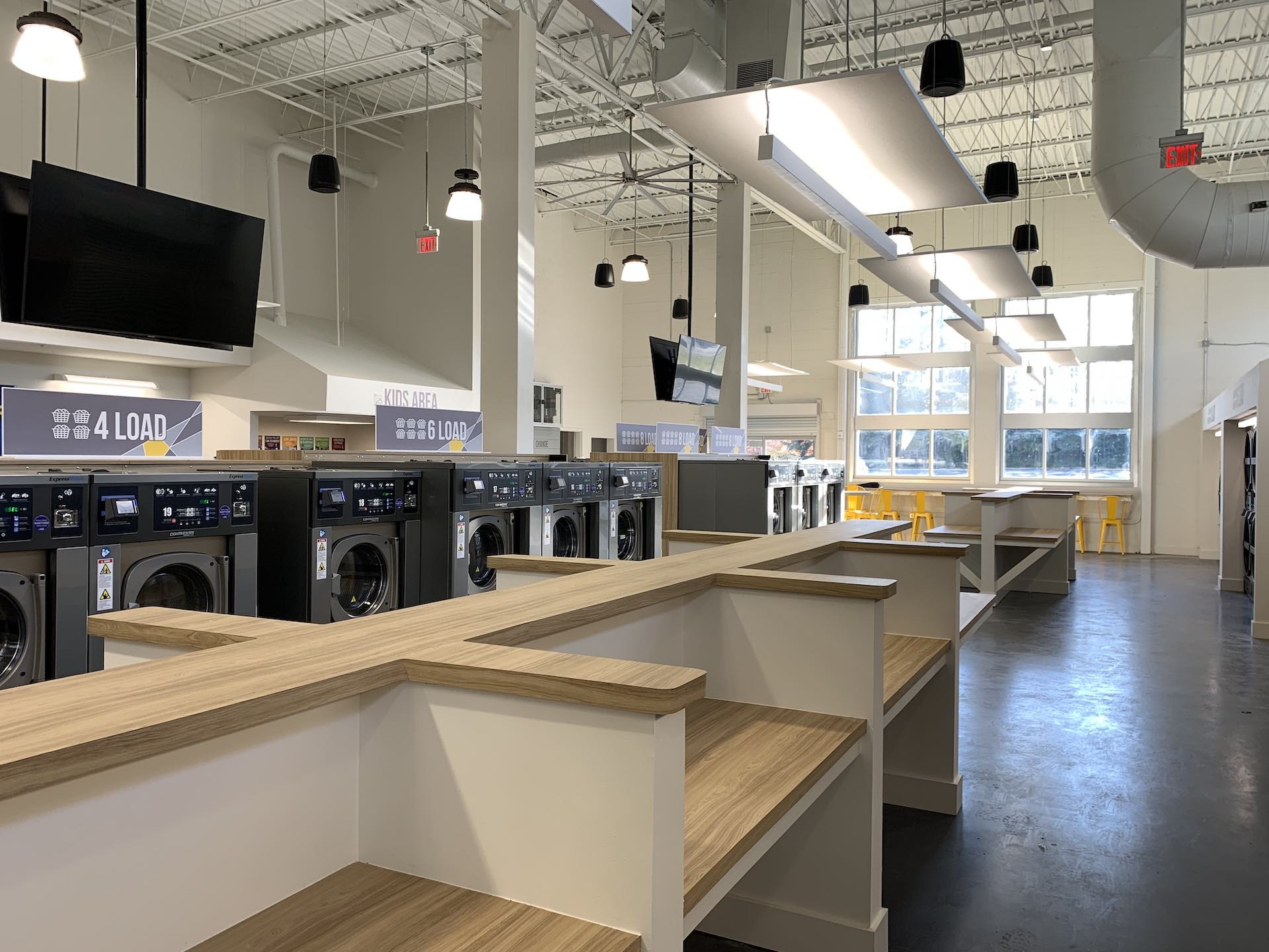 Folding tables beside the 4-load washers at Oz Laundry